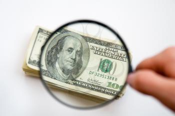 Royalty Free Photo of Money by a Magnifying Glass