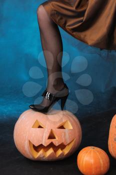 Royalty Free Photo of a Woman Standing on a Pumpkin