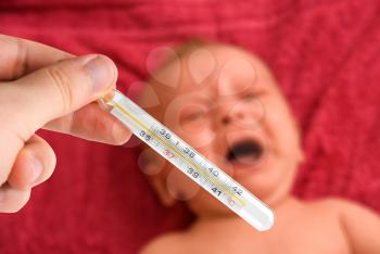 Royalty Free Photo of a Mother Checking Her Baby's Temperature 