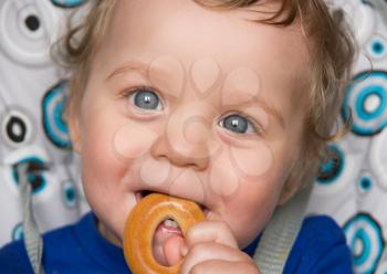 Royalty Free Photo of a Baby Boy Holding a Bread Ring