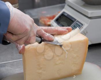 Royalty Free Photo of a Person Cutting a Piece of Cheese