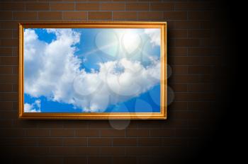 blue sky picture at gold frame on brick wall background