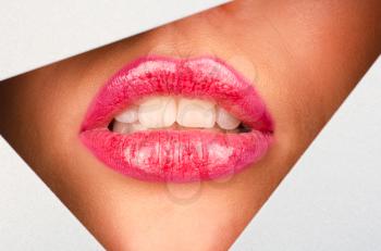 Beautiful female lips closeup behind silver paper background