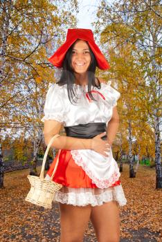 Red Riding hood standing in atumn wood