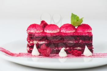 Plate with piece of delicious red velvet cake on white background