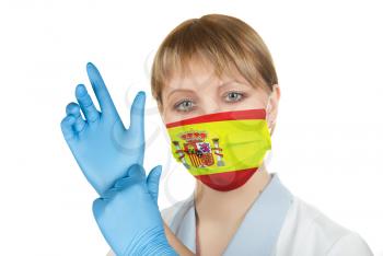 Closeup of a female healthcare professional nurse wearing a protection mask with Spain flag