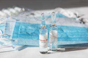 Coronavirus vaccine concept: covid-19 vaccine on the table with blue protective masks.