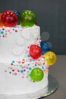 Wedding cake with balloons on grey background
