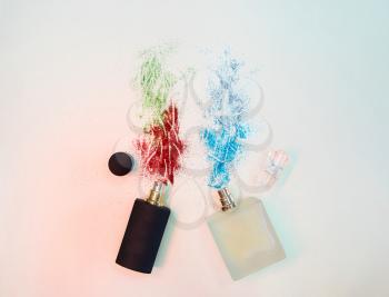 Flat lay composition with two perfume bottles with sparkles on paper background