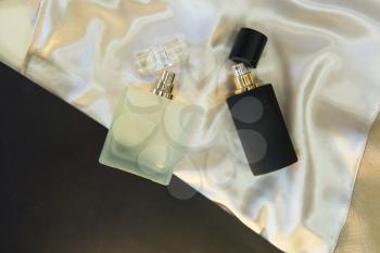 Flat lay composition with two perfume bottles on cloth background