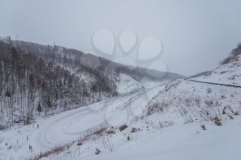 Altai mountains winter road serpentine through mountains pass.
