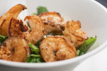 Fried shrimps with yogurt sauce and greens on plate
