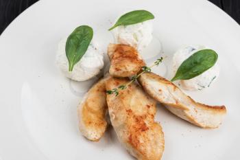 Grilled chicken breast with mozzarella cheese decorated with basil. Concept for a healthy meal.