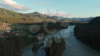 Aerial view of Katun river, in Altai mountains, in beauty summer evening, the boat floats on the river, cinematic drone footage