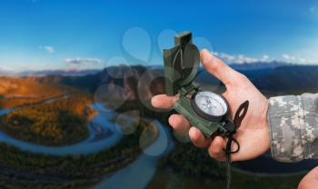 Man with compass in hand in Altai mountains. Travel concept.