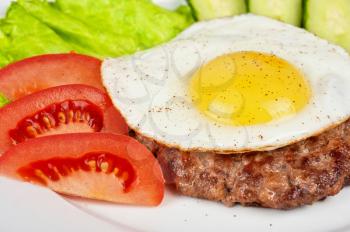 steak beef meat with fried egg, tomato, cucumbers and salad