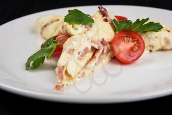 Omelet with Ham and Cheese on black wooden background