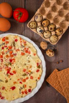 baked omelette with different eggs and vegetables with rye small load of bread