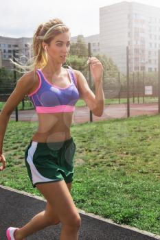 A young beauty athletic woman in sportswear running at outdoor.