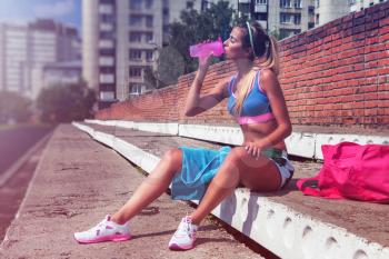 A young beauty athletic woman in sportswear warming-up before exercises and running.