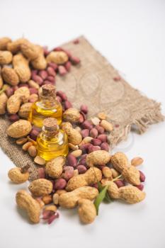 Natural peanuts with oil in a glass jar on a white background