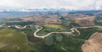 Kurai steppe and Chuya river on North-Chui ridge background. Altai mountains, Russia. Aerial drone panoramic picture. Giant ripples of the flow of water 15 thousand years ago
