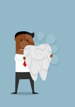 Pleasant smiling cartoon african american businessman standing with a large white healthy tooth in hands. Health insurance or dentistry theme design usage