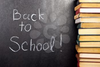 Royalty Free Photo of Back to School Written on Chalkboard With Books