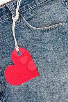 Royalty Free Photo of a Pair of Blue Jeans With a Red Heart Tag Hanging From a Belt Loop