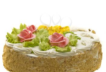 Close-up of tasty cake with cream, pink roses and green leaves