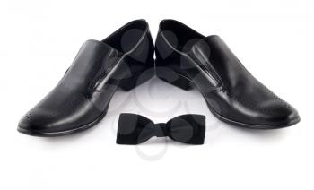 Black bow and men's classic shoes isolated over white