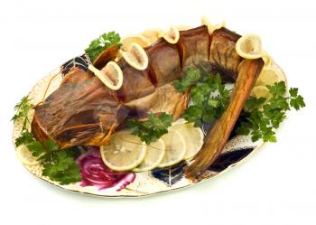 Bloated sheatfish with lemon and parsley on the plate over white