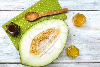 Cut melon with honey on napkin and board in rustic style
