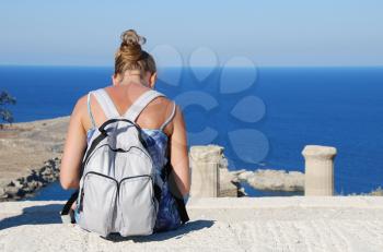 Royalty Free Photo of a Woman With a Backpack Reading in Greece