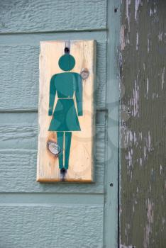 Royalty Free Photo of a Wooden Sign Outside a Women's Washroom