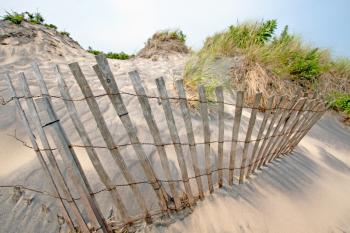 Sand dunes on Atlantic coast with a fence.