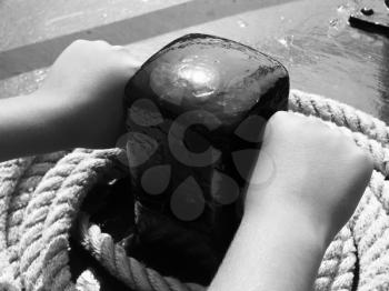 Little boy's hands forcefully gripping iron detail on the yacht. Concept of strength and safety.