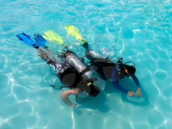 A boy taking scuba diving lessons in the caribbean resort.