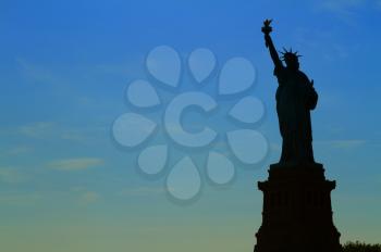 Views of New York City, USA. Staue of Liberty silhouette at sunset.