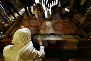 Jerusalem, Israel- March 12, 2017: Pilgrims at the The Stone of Anointing, where Jesus' body is said to have been anointed before burial.