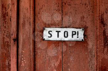 close up of a sign saying ''stop''on the grunge wooden background 