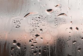 Large and fine water drops on window glass
