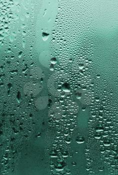 natural large and fine water drops on green glass