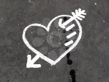 Abstract white heart painted on the dirty pavement                           