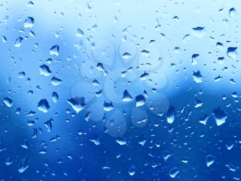 Natural blue background with water drops on glass