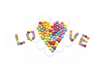 Word ''Love'' and abstract heart from bright colorful candy isolated on white background