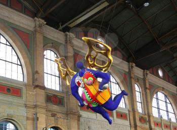 ZURICH HB, SWITZERLAND - MARCH 16, 2015: View of a statue of a guardian angel by Niki de Saint Phalle situated inside of the main train station in Zurich 