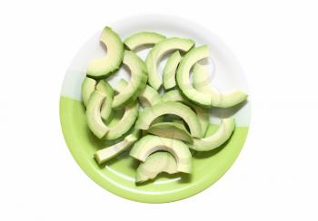 Avocado cut into slices on a plate isolated on white background