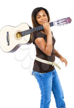 Royalty Free Photo of a Young Girl Holding an Acoustic Guitar over her Shoulder
