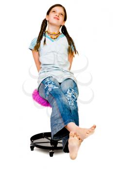 Royalty Free Photo of a Barefoot Girl Sitting on a Stool Daydreaming